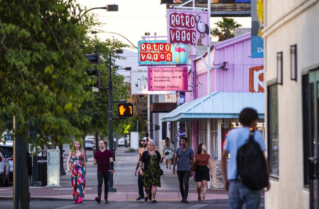 People walking past the Retro Vegas sign on Main Street